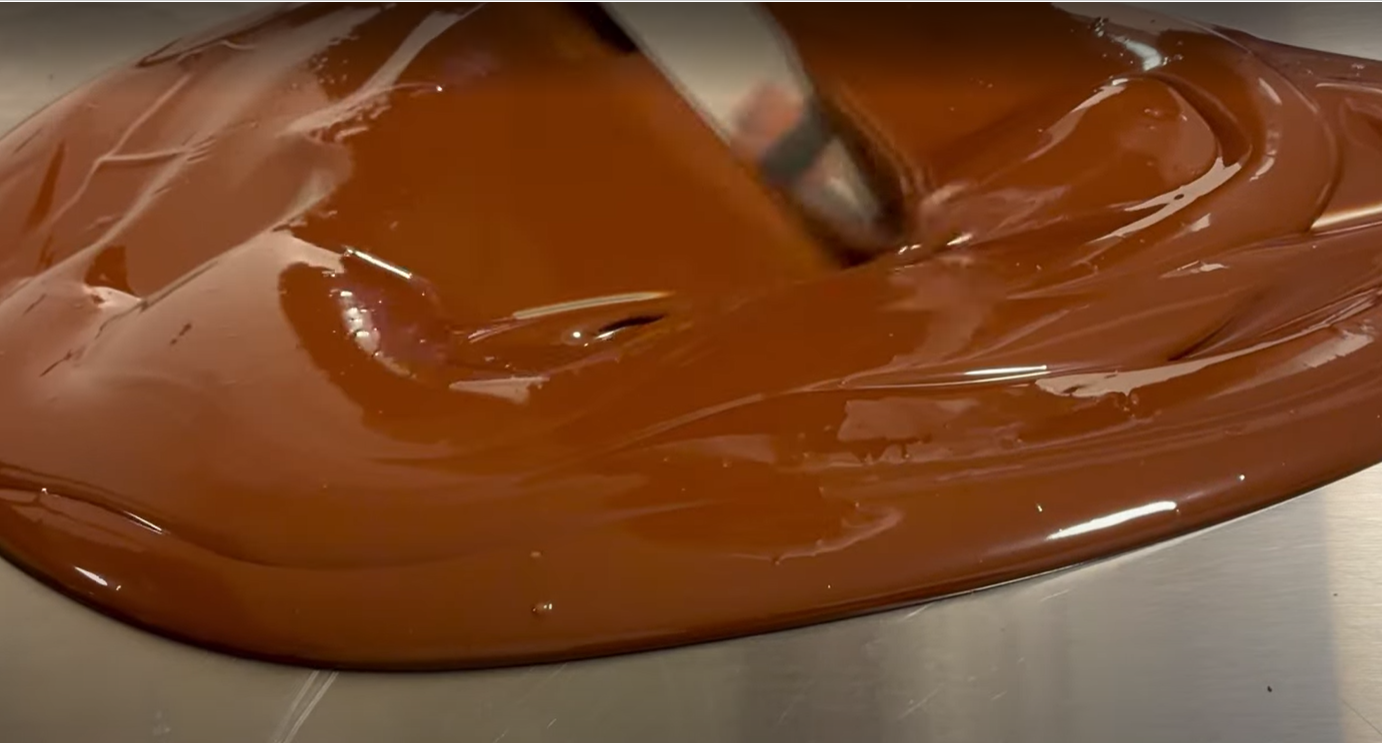 Tempering chocolate on marble with thermometer